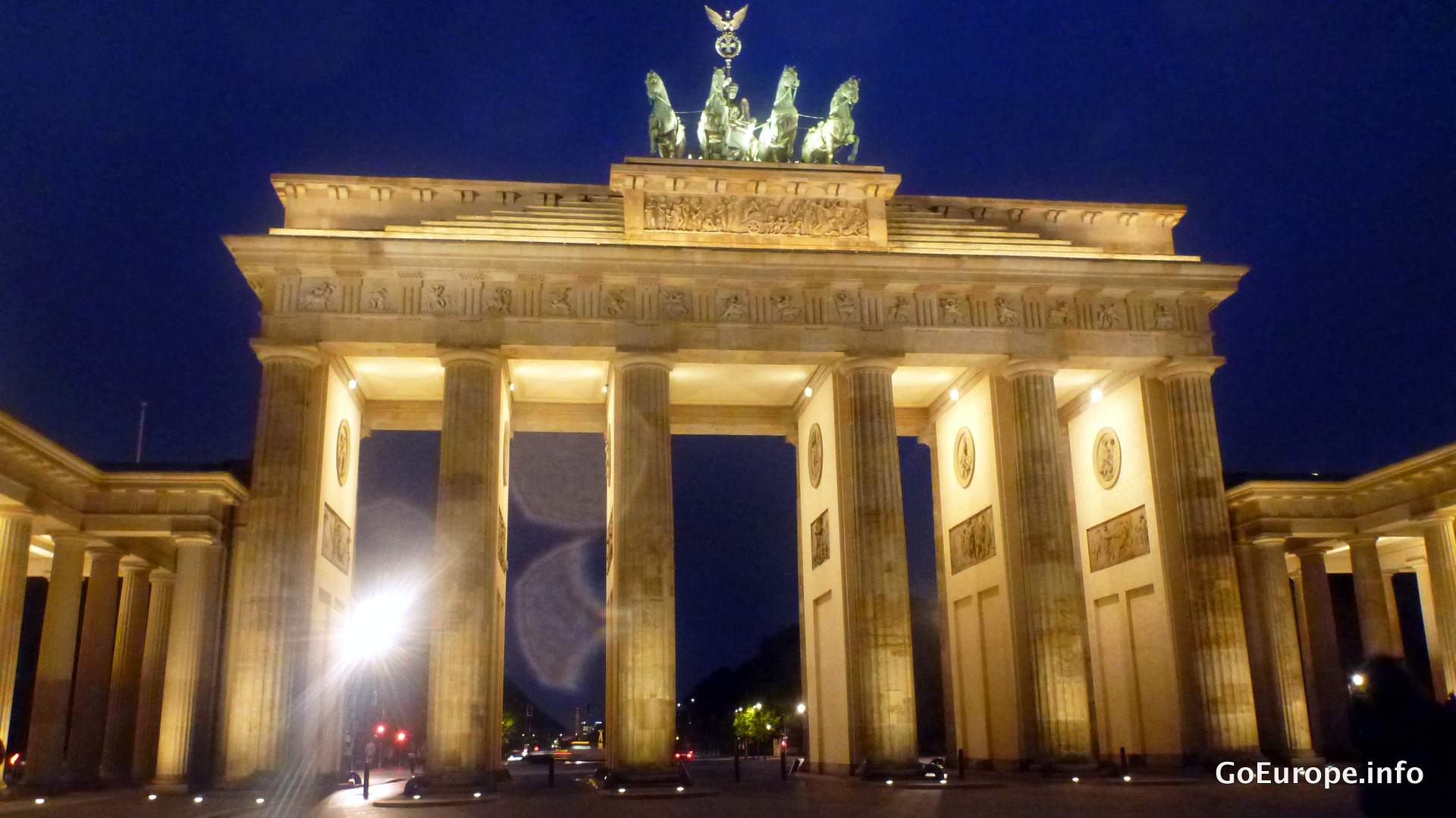 The Brandenburg Gate in central Berlin beneath a blue sky.