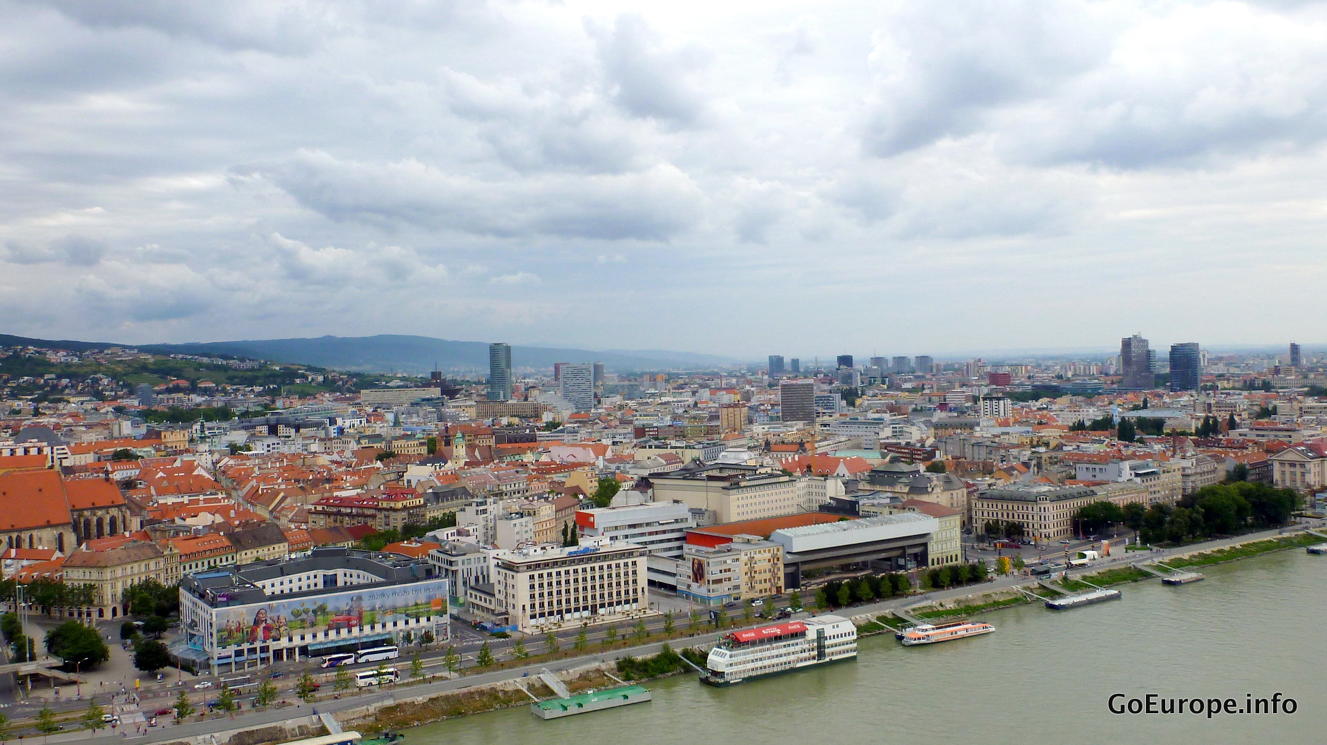 Bratislava rooftops, the Danube and surrounding hills from above.